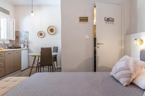 a bedroom with a bed and a kitchen with a table at Porto Galini Kalloni in Agios Ioannis Tinos