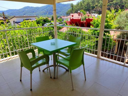 a table and chairs on a balcony with a view at Bucak Apart Hotel Göcek & Beach in Göcek