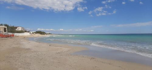 einen Strand mit Meer und blauem Himmel in der Unterkunft Manduria Quality point Stays in Manduria