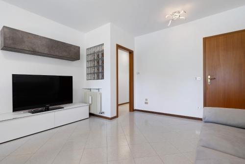 a living room with a flat screen tv on a white wall at Appartamento Cuore di Comano in Comano Terme