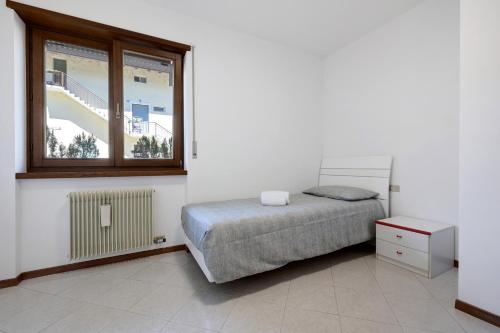 a bedroom with a bed and a window at Appartamento Cuore di Comano in Comano Terme