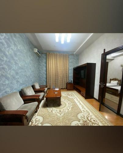 a living room with a couch and a television at Hotel Palace 2 in Andijan