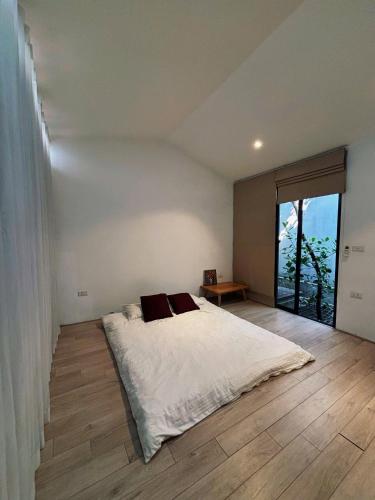 a bedroom with a white bed and a large window at Ng house in Hanoi