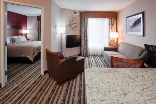 a hotel room with a bed and a living room at GrandStay Residential Suites Hotel in Saint Cloud