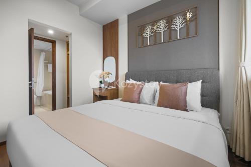 a bedroom with a large white bed in a room at Sivora by Kozystay - Kuningan in Jakarta