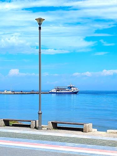 a light pole and a boat in the water at Sea and Sun Luxury apartment in Neoi Epivates