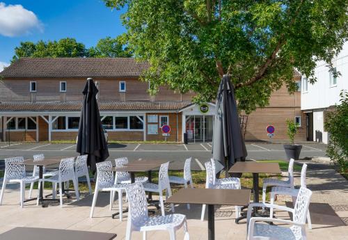 a group of tables and chairs with umbrellas at B&B HOTEL Orleans Saint-Jean de Braye in Saint-Jean-de-Braye
