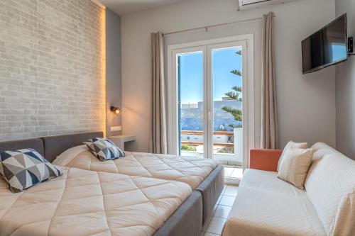 a bedroom with a large bed and a window at Porto Galini Tinos Perastra 103 in Agios Ioannis Tinos