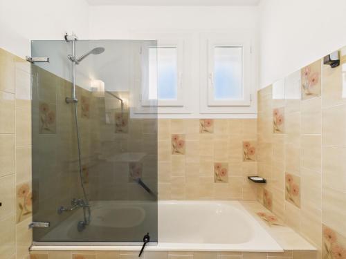 une salle de bain avec une baignoire avec une douche et deux fenêtres dans l'établissement Jardin, 800m de la plage, maison pour 6, à Bretignolles-sur-Mer