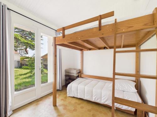 une chambre avec un lit superposé et une fenêtre dans l'établissement Jardin, 800m de la plage, maison pour 6, à Bretignolles-sur-Mer