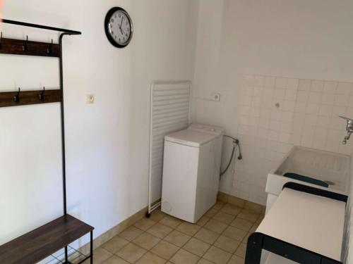 La salle de bains est pourvue de toilettes et d'une horloge murale. dans l'établissement Roselieres de la mer Saint Hilaire de Riez, à Saint-Hilaire-de-Riez