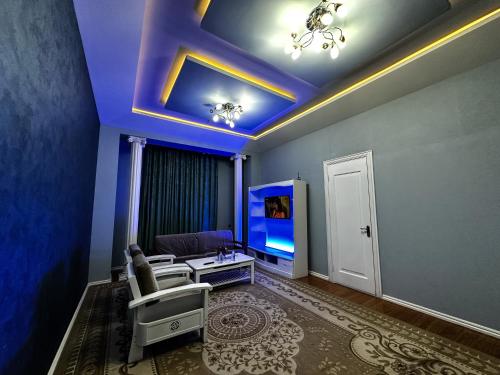 a living room with a couch and a tv at Hotel Palace 2 in Andijan