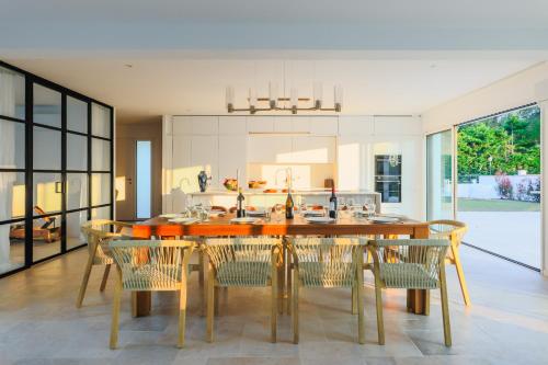 une cuisine et une salle à manger avec une table et des chaises dans l'établissement Superbe villa climatisée 4 chambres, 4 salles de bain avec piscine chauffée proche mer, à Le Bernard