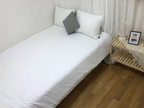 una camera con letto bianco e pavimento in legno di Koong House a Seul