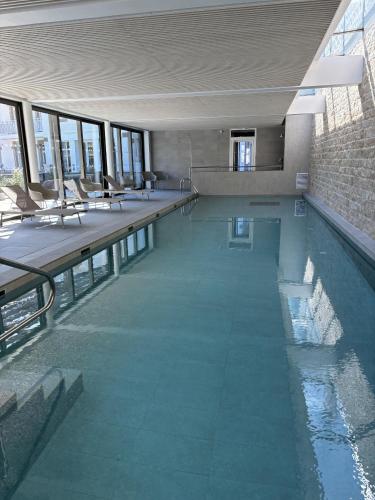 une grande piscine avec des chaises dans un bâtiment dans l'établissement Goas Treiz - T3, à Trébeurden