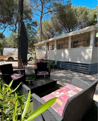- un parking dans une cour avec une table et des chaises dans l'établissement Mobilhome 8 places Oasis Village, à Puget-sur Argens