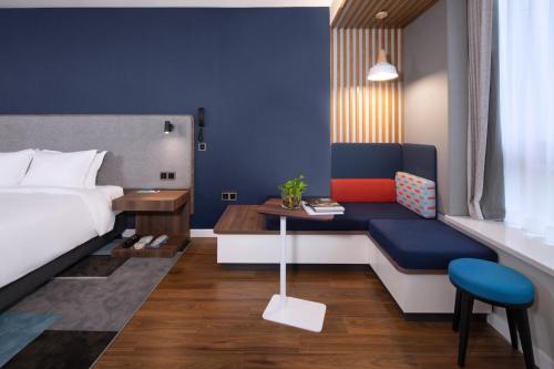 a hotel room with a bed and a table and a couch at Holiday Inn Express Zhoushan Dinghai by IHG in Zhoushan