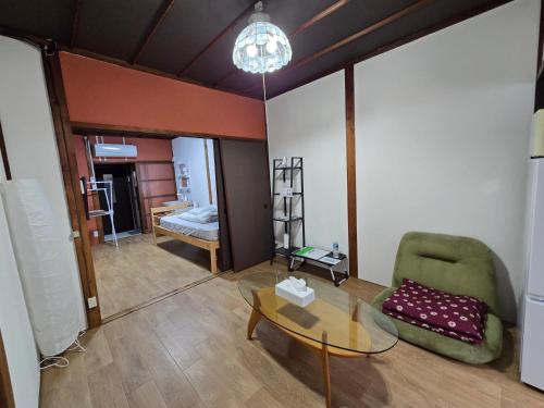 a living room with a glass table and a chair at TSUBAME 103 staying private home in Osaka