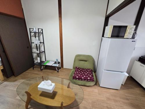 a living room with a table and a refrigerator at TSUBAME 103 staying private home in Osaka