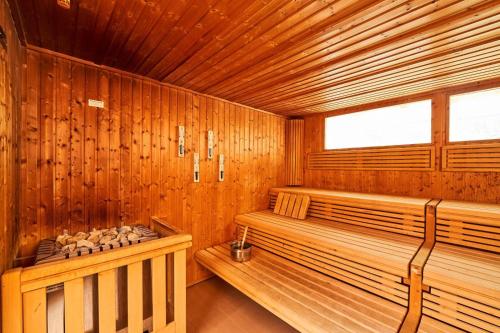 a wooden sauna with two benches and a window at Englmar Apartments with free WELLNESS and FITNESS in Sankt Englmar