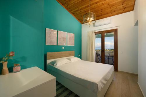 a bedroom with a bed and a blue wall at Thea Divine Comfort & View in Áyioi Dhéka