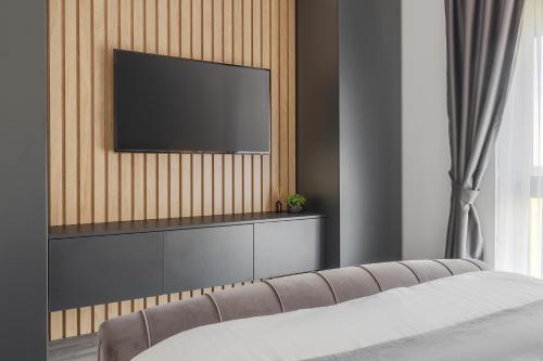 a living room with a television on a wall at FELIX LOTUS - DeLuxe Residence in Baile Felix