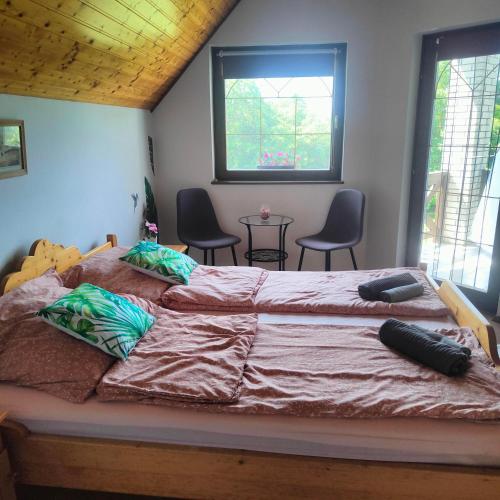 a bedroom with a large bed and two chairs at Balaton Garden in Balatongyörök