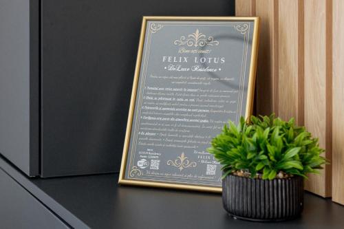a menu in a frame next to a plant on a counter at FELIX LOTUS - DeLuxe Residence in Baile Felix