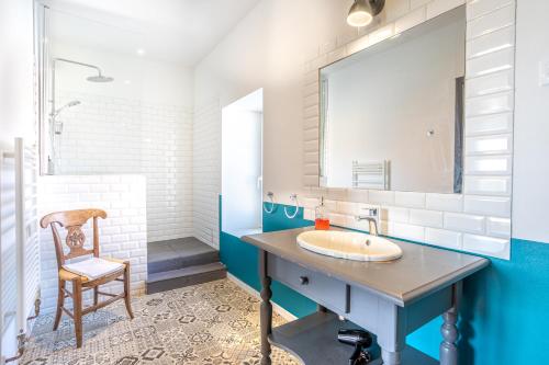 a bathroom with a sink and a chair at Les Jardins de Xanton in Xanton-Chassenon