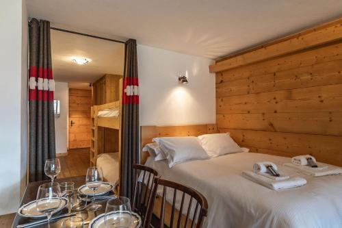 a room with a bed and a table with glasses on it at La Ruinette-spacious studio in Verbier centre in Verbier