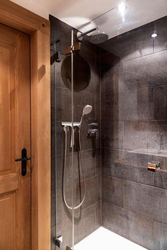 a bathroom with a shower with a glass door at La Ruinette-spacious studio in Verbier centre in Verbier