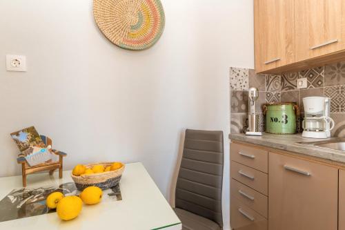 a kitchen with a bowl of fruit on a counter at Porto Galini Tinos Karya 102 in Agios Ioannis Tinos