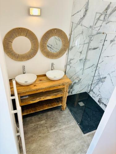 une salle de bain avec deux lavabos et une douche dans l'établissement Le cœur de joli village Français, à Gontaud-de-Nogaret