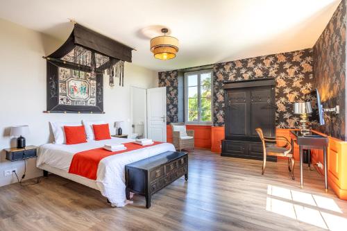 a bedroom with a king sized bed and a desk at Les Jardins de Xanton in Xanton-Chassenon