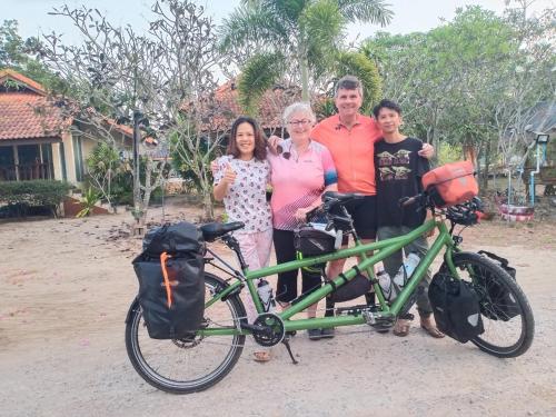 a group of people standing next to a green bike at Wandee Resort Bankrut in Ban Krut