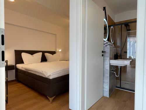 a bedroom with a bed and a bathroom with a sink at Spreewaldapartments-Kossatz in Lübben