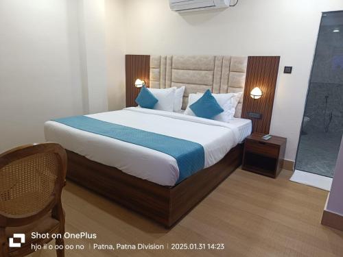 a bedroom with a large bed with blue pillows at Aquila Hotel and Convention by The Nexus in Patna