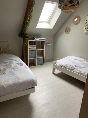 une chambre avec un lit et une lucarne dans l'établissement Aux Petits Bonheurs, à Grandcamp-Maisy