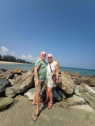 a man and woman standing on rocks on the beach at Wandee Resort Bankrut in Ban Krut
