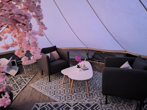 a room with two chairs and a table in a tent at lodge romantique "plein champ" et son jacuzzi privatif in Lapalisse