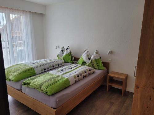 een slaapkamer met 2 bedden en groene kussens bij Haus Perle in Saas-Fee