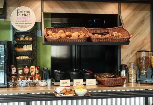 a bakery with baskets of bread on a counter at B&B HOTEL Paris Gennevilliers Asnières in Gennevilliers