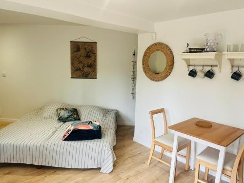 a bedroom with a bed and a table and a table and chair at Anglet Chiberta - Proche plage -Terrasse in Anglet