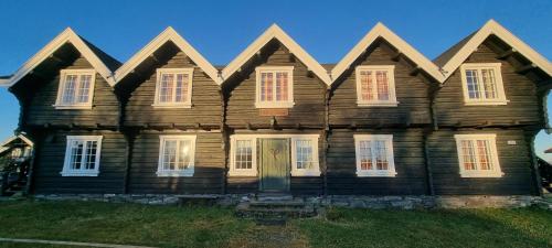 an old wooden house with white windows and a door at Langleiken in Sør-Fron