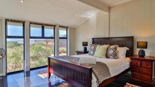 a bedroom with a large bed and a large window at BluCabana 500m from Main Beach in Bettyʼs Bay