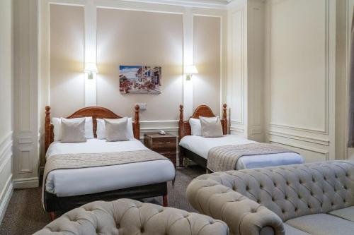 a hotel room with two beds and a couch at Adelphi Hotel in Liverpool