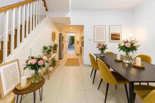 a dining room with a black table and yellow chairs at 3BR Glebe Retro Jungle Escape Near Darling Harbour in Sydney