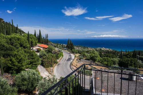a winding road on a hill next to the ocean at Maria's Sea View Apartments in Mousata