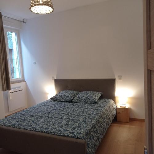 une chambre avec un lit avec deux oreillers dessus dans l'établissement Gîte les Chapélétas au cœur de l'Ardeche, à Saint Alban Auriolles