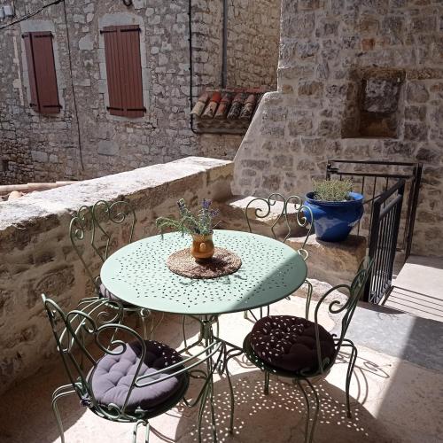 une table et des chaises vertes sur la terrasse dans l'établissement Gîte les Chapélétas au cœur de l'Ardeche, à Saint Alban Auriolles